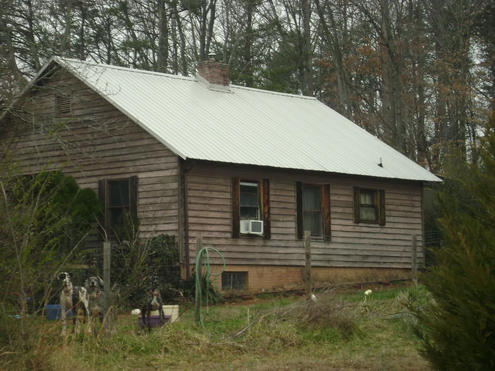 White metal roof on an old wood sided farmhouse, from a Metal Roof Installation job in Huron